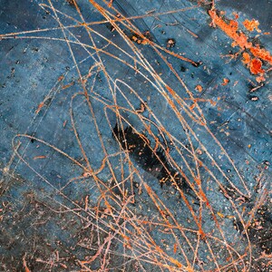 May include: Abstract background with a blue, gray, and black surface with orange and pink scratches and streaks.