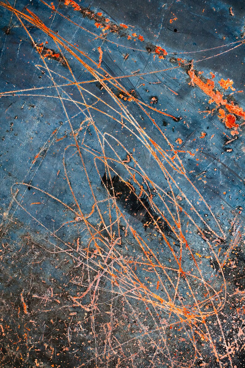 May include: Abstract background with a blue, gray, and black surface with orange and pink scratches and streaks.