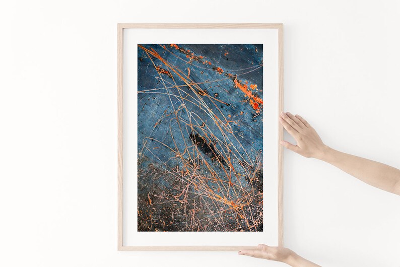 May include: Abstract art print with a blue background and orange and white lines. The print is framed in a light wood frame.