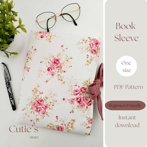 May include: A white book sleeve with a floral pattern of pink roses and green leaves. The text "Book Sleeve" and "One size" are visible. A pair of glasses and a pen are also in the image.