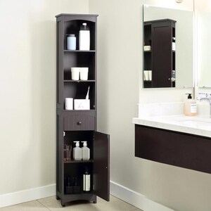 May include: A dark brown bathroom storage cabinet with open shelving and a lower cabinet with a single drawer. The cabinet is filled with toiletries, including bottles, cups, and a toothbrush. The cabinet is tall and narrow, designed to fit in a small space.