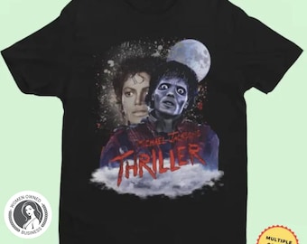 May include: Black t-shirt featuring a graphic of Michael Jackson from the "Thriller" music video. The design includes a portrait of Jackson, a zombie image, a full moon, and the word "Thriller" in red letters.
