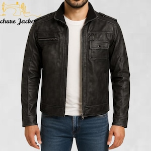 May include: Black leather jacket with a zip closure, multiple pockets, and a stand-up collar. The jacket has a textured appearance and is worn over a white t-shirt and blue jeans. The brand name "Stitchure Jacke" is visible in the upper left corner.