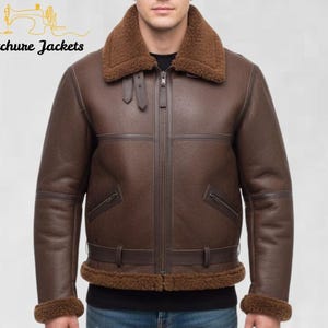 Puede incluir: Chaqueta de cuero marrón con cuello y puños de borrego. La chaqueta tiene cierre de cremallera, dos bolsillos delanteros y un cinturón en la cintura. El texto "Stitchure Jackets" está en la esquina superior izquierda.