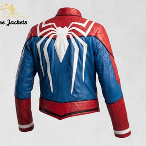 May include: A red and blue leather jacket featuring a large white spider emblem on the back. The jacket has a stand-up collar, long sleeves with red and white cuffs, and black piping details. The text Stitchure Jackets appears in the top left corner.