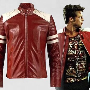 May include: A red leather jacket featuring a stand-up collar with a snap button, white shoulder panels, and two horizontal white stripes on each sleeve. The jacket includes a central zipper closure and two vertical side pockets on the front.