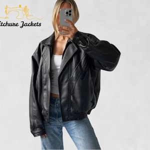 Könnte beinhalten: Schwarze Lederjacke mit klassischem Design. Die Jacke hat einen breiten Kragen, einen Reißverschluss und einen gerippten Saum. Das Stitchure Jackets-Logo ist oben links sichtbar.