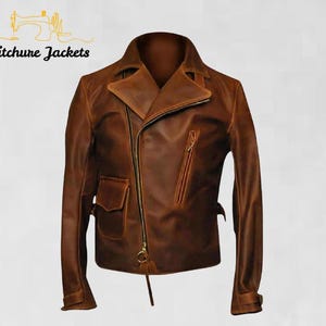 Pode incluir: Casaco de couro castanho com fecho de correr assimétrico, um bolso pequeno e um bolso no peito com fecho de correr. O casaco tem gola entalhada e mangas compridas com punhos com fecho de correr. A marca "Stitchure Jackets" está impressa em preto.