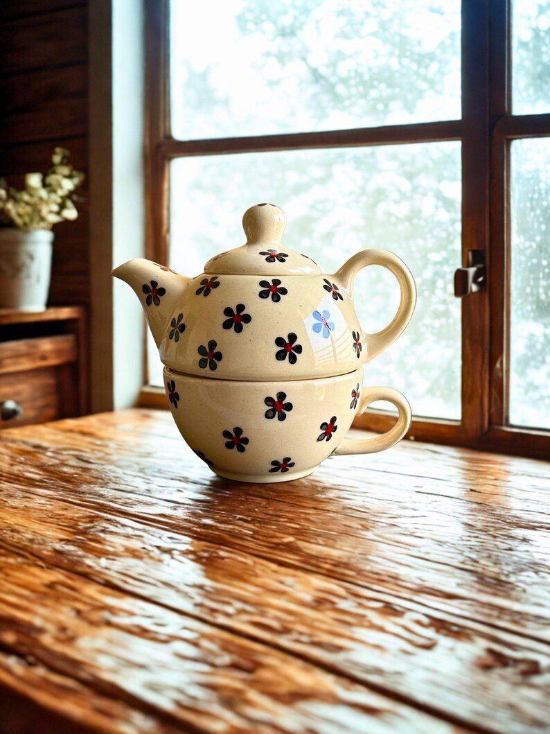 May include: A set of three ceramic mugs with a speckled, matte finish. The mugs are in shades of cream, light gray, and dark gray. Each mug has a simple, minimalist design and a rounded handle.