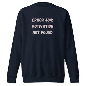 Könnte beinhalten: Marineblaues Sweatshirt mit dem Text "ERROR 404: MOTIVATION NOT FOUND" in hellem Rosa. Das Sweatshirt hat einen Rundhalsausschnitt und lange Ärmel. Ein lässiges, bequemes Kleidungsstück.