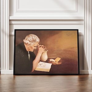 Op de afbeelding: Ingelijst kunstwerk dat een oudere persoon met gevouwen handen, een boek en een kruik op een tafel afbeeldt. Het schilderij heeft een warm kleurenpalet, met de nadruk op het gezicht en de handen van het onderwerp. Het kunstwerk zit in een zwarte lijst.