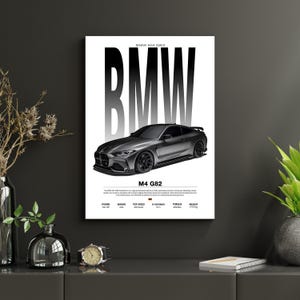 May include: A framed print featuring a gray BMW M4 G82 sports car illustration. The word "BMW" is displayed in large, bold, grayscale letters above the car. Below the car, the text "M4 G82" is printed. Additional specifications are listed below.