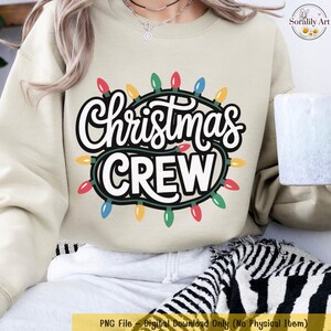 May include: A beige sweatshirt with the words "Christmas CREW" in a white, bold font, surrounded by a string of colorful Christmas lights. The sweatshirt is a digital download, perfect for holiday apparel.