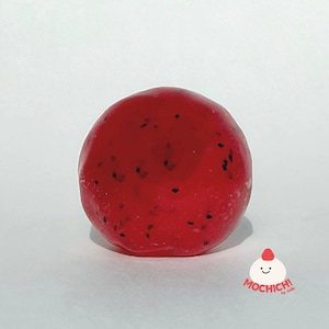 May include: A round, translucent red mochi treat with small black specks throughout its surface. In the bottom right corner, there is a small white logo featuring a smiling face and the red text MOCHICH! by Jolin.