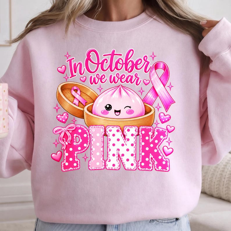 In October We Wear Pink breast cancer awareness PNG featuring a cute pink dumpling in a bamboo steamer, pink ribbon, hearts, bows, sparkles, and polka-dot lettering.