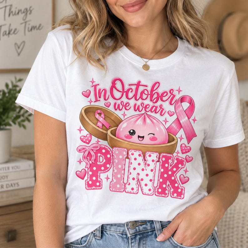 In October We Wear Pink breast cancer awareness PNG featuring a cute pink dumpling in a bamboo steamer, pink ribbon, hearts, bows, sparkles, and polka-dot lettering.