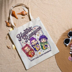 A product mockup showing a vibrant Huntrix Kpop Demon Hunters graphic applied to a physical item. The print highlights the vivid colors and crisp details of the Saja Girls anime PNG design, demonstrating its perfect application for sublimation and DTG printing.