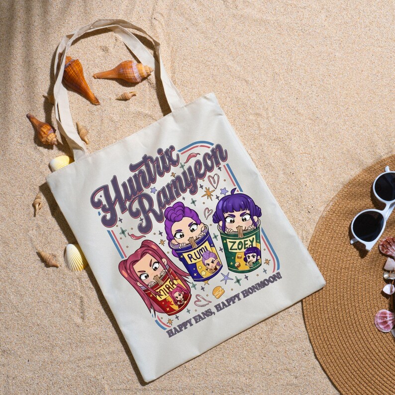 A product mockup showing a vibrant Huntrix Kpop Demon Hunters graphic applied to a physical item. The print highlights the vivid colors and crisp details of the Saja Girls anime PNG design, demonstrating its perfect application for sublimation and DTG printing.