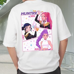 A product mockup showing a vibrant Huntrix Kpop Demon Hunters graphic applied to a physical item. The print highlights the vivid colors and crisp details of the Saja Girls anime PNG design, demonstrating its perfect application for sublimation and DTG printing.