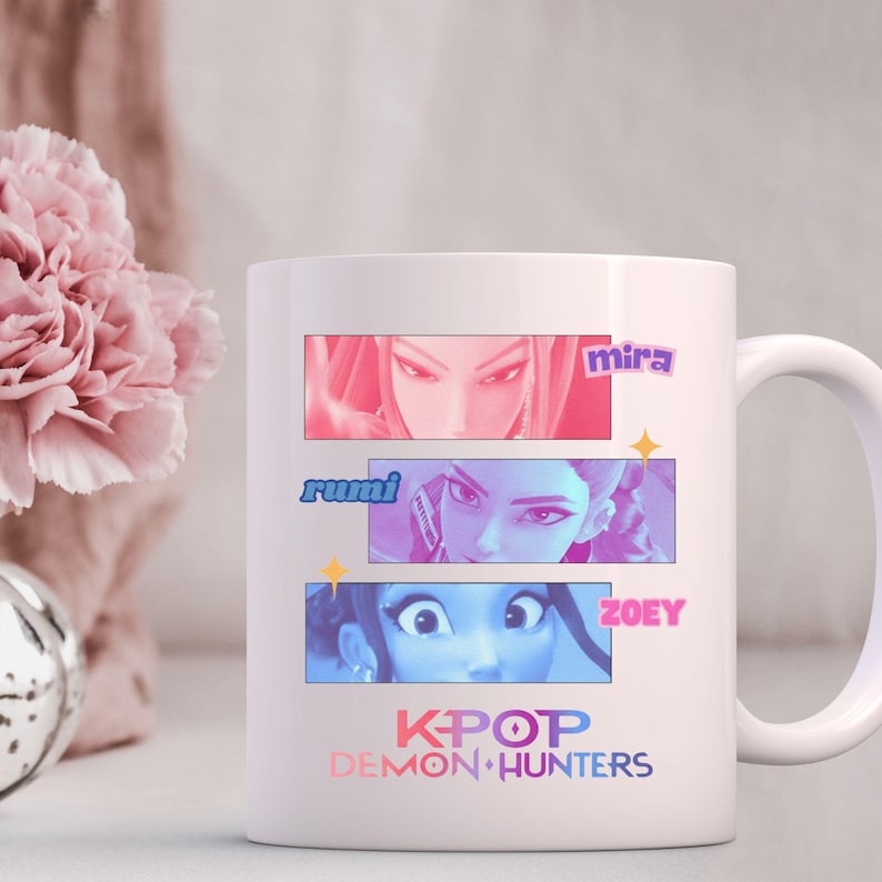 A product mockup showing a vibrant Huntrix Kpop Demon Hunters graphic applied to a physical item. The print highlights the vivid colors and crisp details of the Saja Girls anime PNG design, demonstrating its perfect application for sublimation and DTG printing.