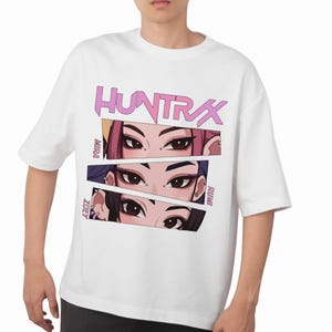 A product mockup showing a vibrant Huntrix Kpop Demon Hunters graphic applied to a physical item. The print highlights the vivid colors and crisp details of the Saja Girls anime PNG design, demonstrating its perfect application for sublimation and DTG printing.