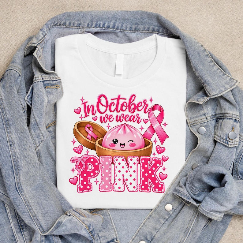 In October We Wear Pink breast cancer awareness PNG featuring a cute pink dumpling in a bamboo steamer, pink ribbon, hearts, bows, sparkles, and polka-dot lettering.