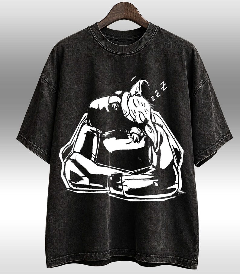 K&ouml;nnte beinhalten: Schwarzes T-Shirt mit einer wei&szlig;en Grafik einer schlafenden Person, mit dem Wort &bdquo;zzz&ldquo; &uuml;ber dem Kopf. Das Shirt hat einen Vintage-Look und einen Rundhalsausschnitt.