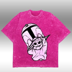 Peut inclure: T-shirt magenta avec une illustration en noir et blanc d'un personnage d'une franchise de science-fiction populaire. Le dessin repr&eacute;sente une cr&eacute;ature ressemblant &agrave; un b&eacute;b&eacute; tenant un casque.