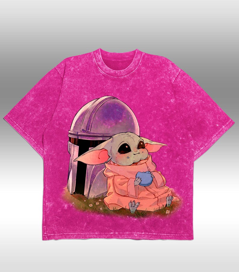 May include: A vibrant pink t-shirt with a cartoon illustration of a character in a pink robe holding a blue item, set against a helmet. The shirt has a textured, faded look.
