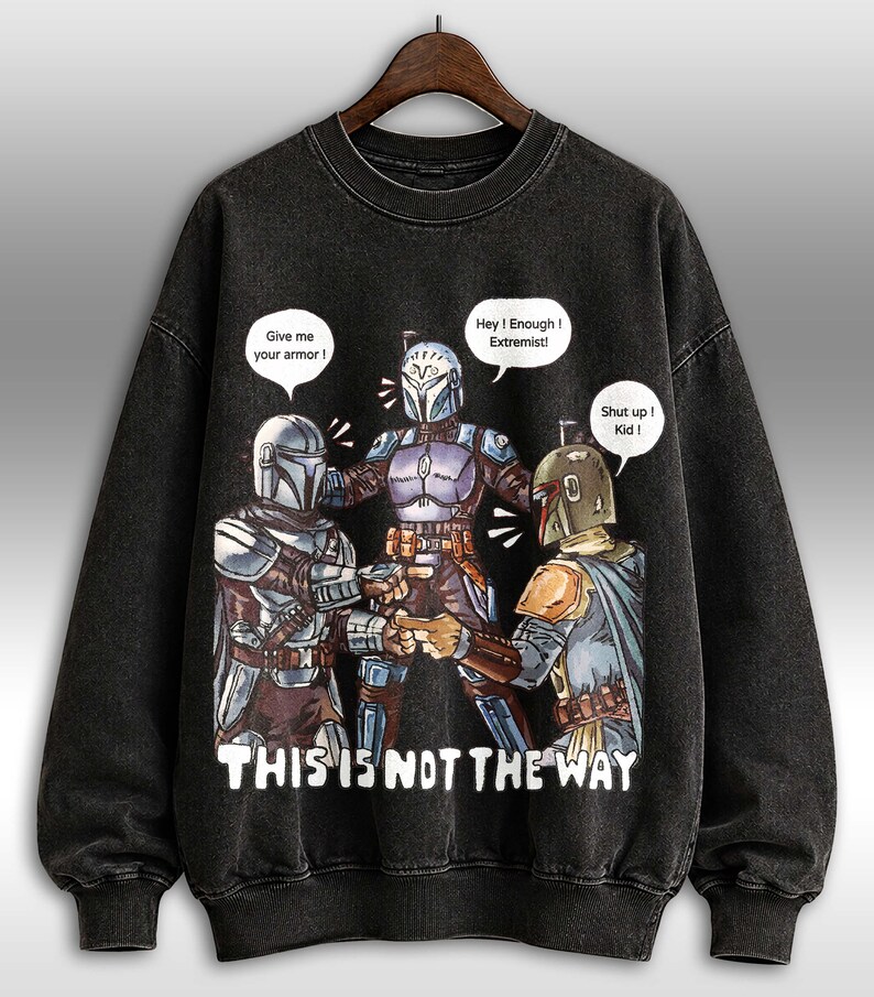 K&ouml;nnte beinhalten: Schwarzes Sweatshirt mit Rundhalsausschnitt und einer Grafik von drei Charakteren in R&uuml;stungen mit Sprechblasen. Der Text "THIS IS NOT THE WAY" ist unter den Charakteren aufgedruckt. Die Sprechblasen sagen "Give me your armor!", "Hey! Enough! Extremist!" und "Shut up! Kid!"