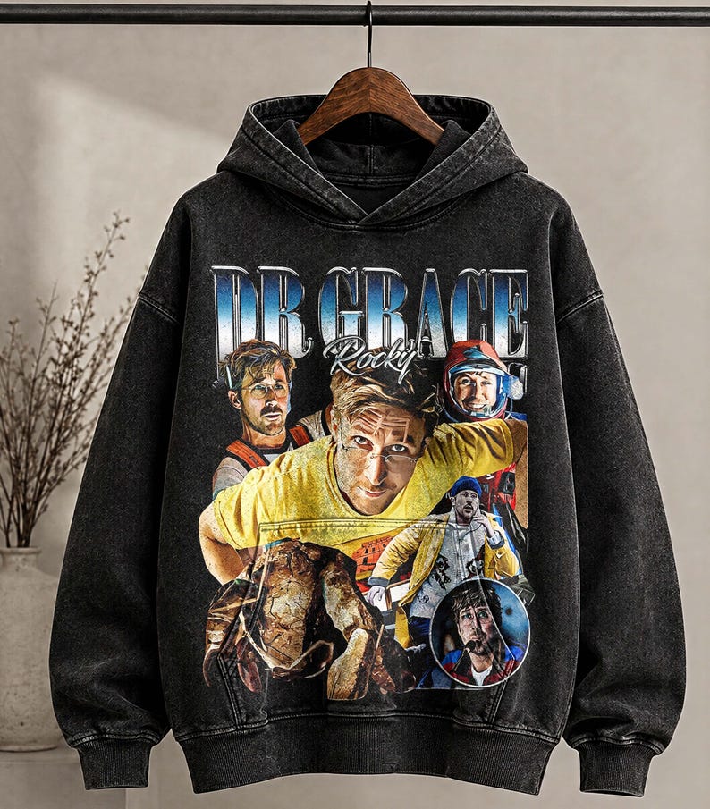May include: Black hooded sweatshirt with a distressed graphic featuring the text "DR GRACE Rocky" and multiple images of a person. The sweatshirt has long sleeves and a drawstring hood.