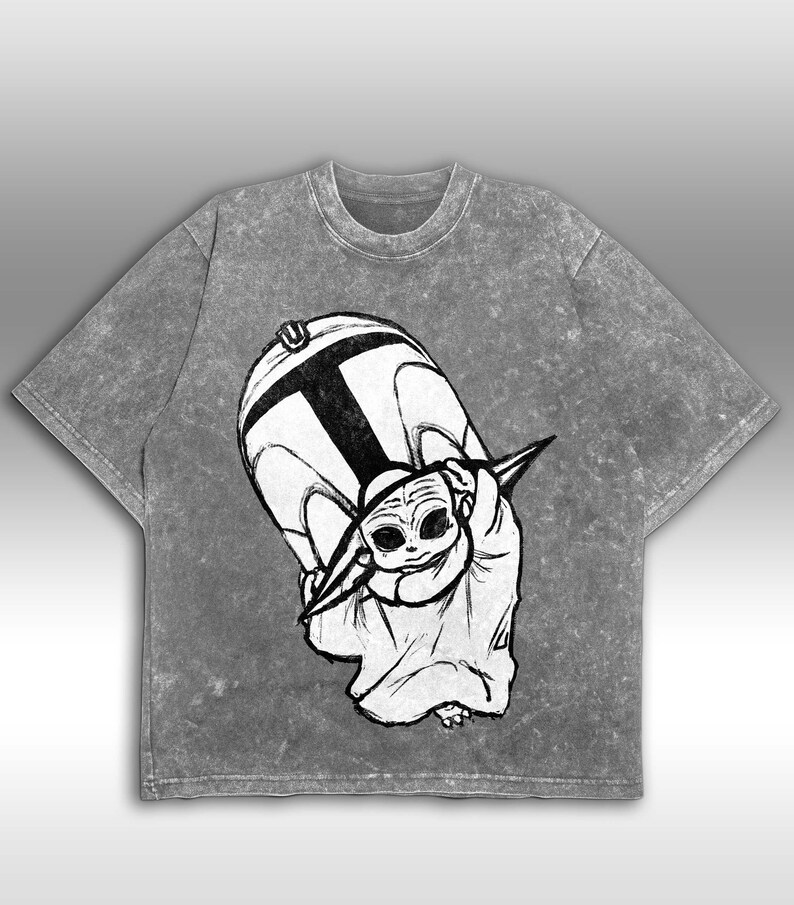 Peut inclure: T-shirt gris d&eacute;lav&eacute; &agrave; l'acide avec une illustration en noir et blanc d'un personnage d'une franchise de science-fiction populaire. Le graphisme repr&eacute;sente un grand casque et une petite cr&eacute;ature extraterrestre. Le t-shirt a un col rond et des manches courtes.