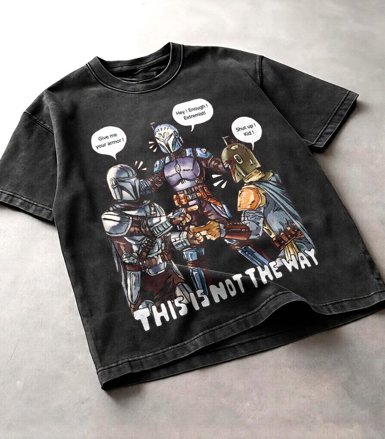 K&ouml;nnte beinhalten: Schwarzes Grafik-T-Shirt mit einer Illustration zum Thema Star Wars. Das Design zeigt drei Charaktere in mandalorianischer R&uuml;stung mit Sprechblasen. Der Text auf dem Shirt lautet "THIS IS NOT THE WAY".