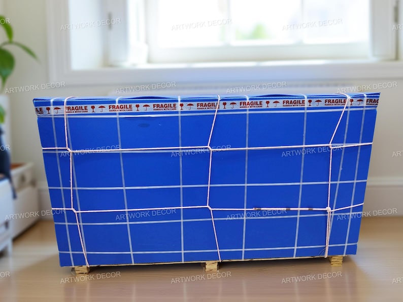 May include: A rectangular blue shipping crate wrapped in white grid lines and secured with thin white cord. The top edge features a repeating white tape strip printed with the word FRAGILE and umbrella icons. The crate rests on small wooden blocks.
