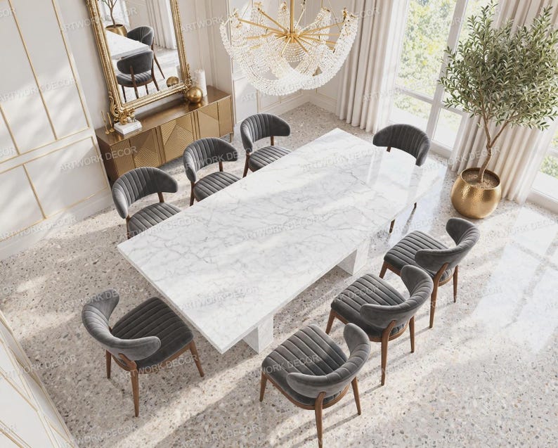 May include: A rectangular white marble dining table with gray veining, paired with eight dark gray upholstered chairs featuring vertical channel tufting and wooden legs, arranged in a formal dining room setting with a large crystal chandelier.