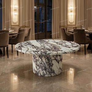 May include: A round dining table featuring a white marble top with prominent dark purple and black veining. The table is supported by a thick, cylindrical pedestal base that matches the marble surface, showcasing a fluted, vertical texture.