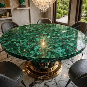 Può includere: Un tavolo da pranzo rotondo con un piano in malachite verde vibrante. Il tavolo ha una base a piedistallo color oro ed è circondato da sedie grigio scuro. Un lampadario di cristallo è appeso sopra il tavolo, con una vista sul verde sullo sfondo.