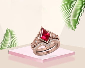 May include: A rose gold ring set with a striking, kite-shaped red gemstone. The ring is embellished with small, sparkling white stones and decorative filigree. The set includes a matching band, offering a coordinated and elegant appearance.