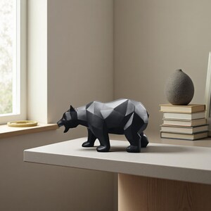 May include: A black geometric bear sculpture with a polygonal design. The bear is standing on a light-coloured surface. The sculpture is a decorative item, suitable for home décor.