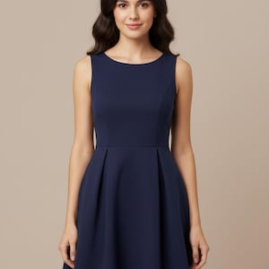 May include: Sleeveless navy blue dress with a scoop neckline and a pleated skirt. The dress has a fitted bodice and a flared skirt, creating a classic silhouette. The fabric appears smooth and has a slight sheen.