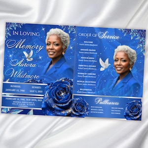 May include: A memorial service program with a blue and white design. The program features a portrait of a woman, floral accents, and text including "In Loving Memory" and "Order of Service."