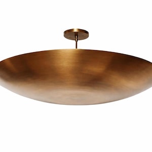 K&ouml;nnte beinhalten: Eine gro&szlig;e, bronzefarbene Deckenleuchte. Die Leuchte hat eine breite, flache Schalenform und einen zentralen Stiel, der an einer kreisf&ouml;rmigen Deckenhalterung befestigt ist. Das Metall hat eine warme, geb&uuml;rstete Oberfl&auml;che.