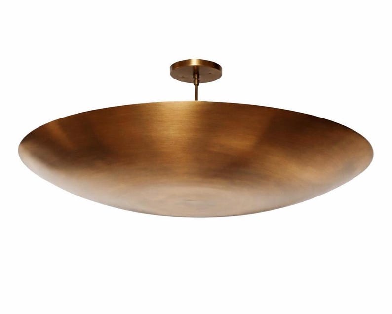 K&ouml;nnte beinhalten: Eine gro&szlig;e, bronzefarbene Deckenleuchte. Die Leuchte hat eine breite, flache Schalenform und einen zentralen Stiel, der an einer kreisf&ouml;rmigen Deckenhalterung befestigt ist. Das Metall hat eine warme, geb&uuml;rstete Oberfl&auml;che.