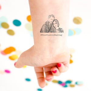 Op de afbeelding: Een tijdelijke tattoo met een zwart-witte lijntekening van een stel. Het stel omarmt elkaar en de vrouw draagt een jurk. De tattoo bevat de tekst "#YourCustomHashtag".