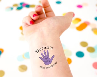 May include: A temporary tattoo on a wrist with the text "Norah's HI FIVE 5th Birthday". The design features a purple handprint with the words "HI FIVE" inside. The background includes colorful confetti.