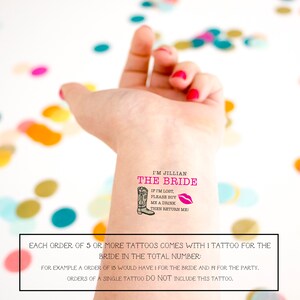 Pu&ograve; includere: Un tatuaggio temporaneo su un polso con il testo I'M JILLIAN THE BRIDE in rosa, un'illustrazione di uno stivale da cowboy nero, un'icona di labbra rosa e il testo nero IF I'M LOST, PLEASE BUY ME A DRINK THEN RETURN ME. Il design &egrave; nitido.