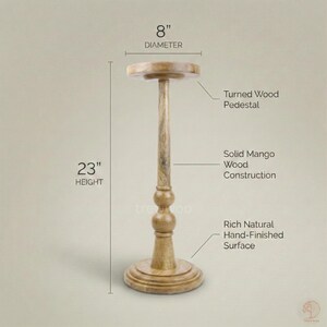 May include: A turned wood pedestal with a rich, natural, hand-finished surface. The solid mango wood pedestal is 23 inches high and 8 inches in diameter. The pedestal has a round base and a turned wood design.