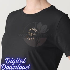 Pu&ograve; includere: T-shirt nera con un design circolare con le parole "Spooky Vibes" e un'illustrazione di pipistrello. Un fiore stilizzato &egrave; accanto al disegno. Le parole "Digital Download" sono nella parte inferiore dell'immagine.
