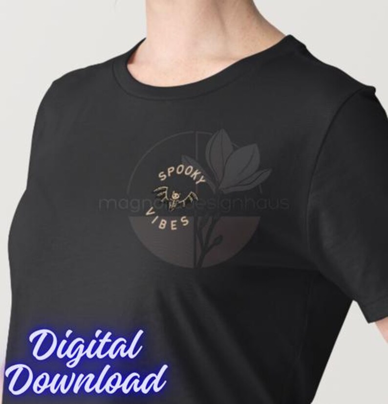 Pu&ograve; includere: T-shirt nera con un design circolare con le parole "Spooky Vibes" e un'illustrazione di pipistrello. Un fiore stilizzato &egrave; accanto al disegno. Le parole "Digital Download" sono nella parte inferiore dell'immagine.