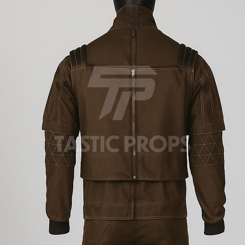 Pu&ograve; includere: Giacca marrone con collo alto e cerniera centrale. La giacca presenta cuciture geometriche sulle maniche e la scritta "TASTIC PROPS". Design unico.